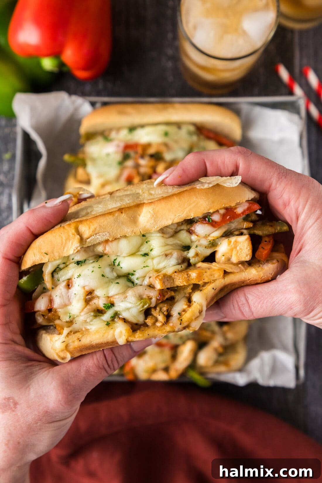 Hands holding a Chicken Philly Cheesesteak