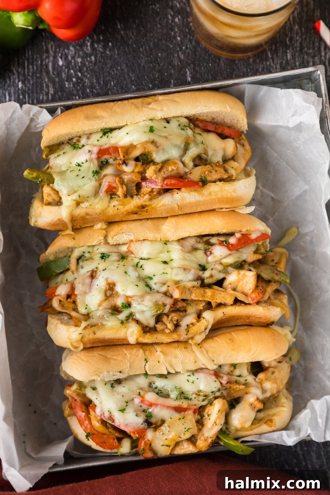 Three Chicken Philly Cheesesteaks in a metal serving tray