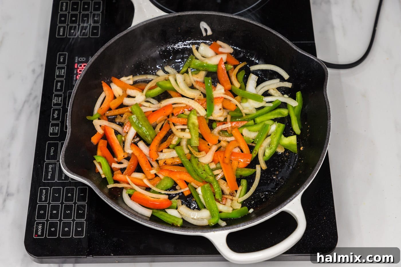 sliced bell peppers and onion sauteed in a skillet