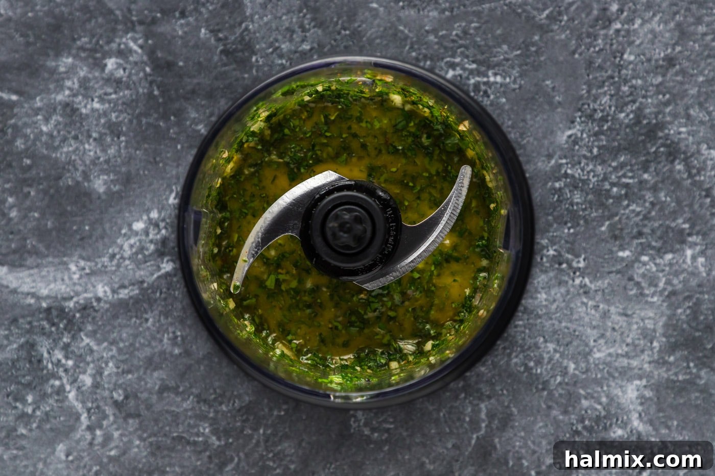 Perfectly Pulsed Chimichurri Mix Coarsely blitzed chimichurri ingredients in a mini food chopper, showing the ideal texture.