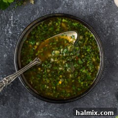 Ready to Serve Chimichurri Close up photo of a bowl of Chimichurri with a spoon in it