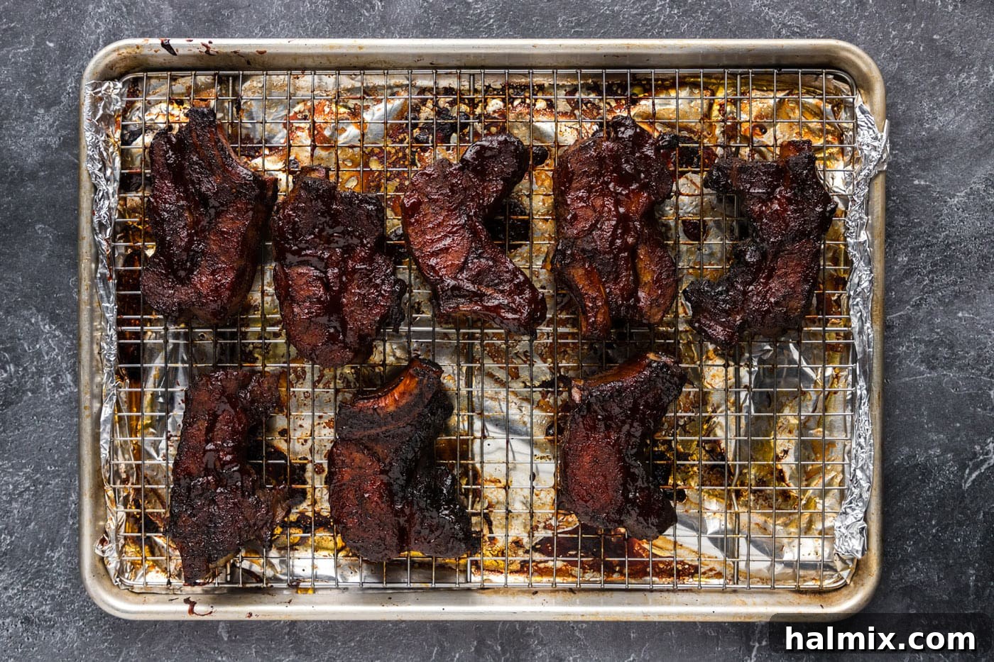 Freshly baked country style pork ribs, generously brushed with barbecue sauce and ready to be returned to the oven for glazing.