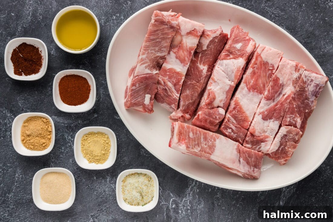 A selection of fresh ingredients laid out, including country style ribs, a bowl of spice rub, and barbecue sauce, all set for cooking.