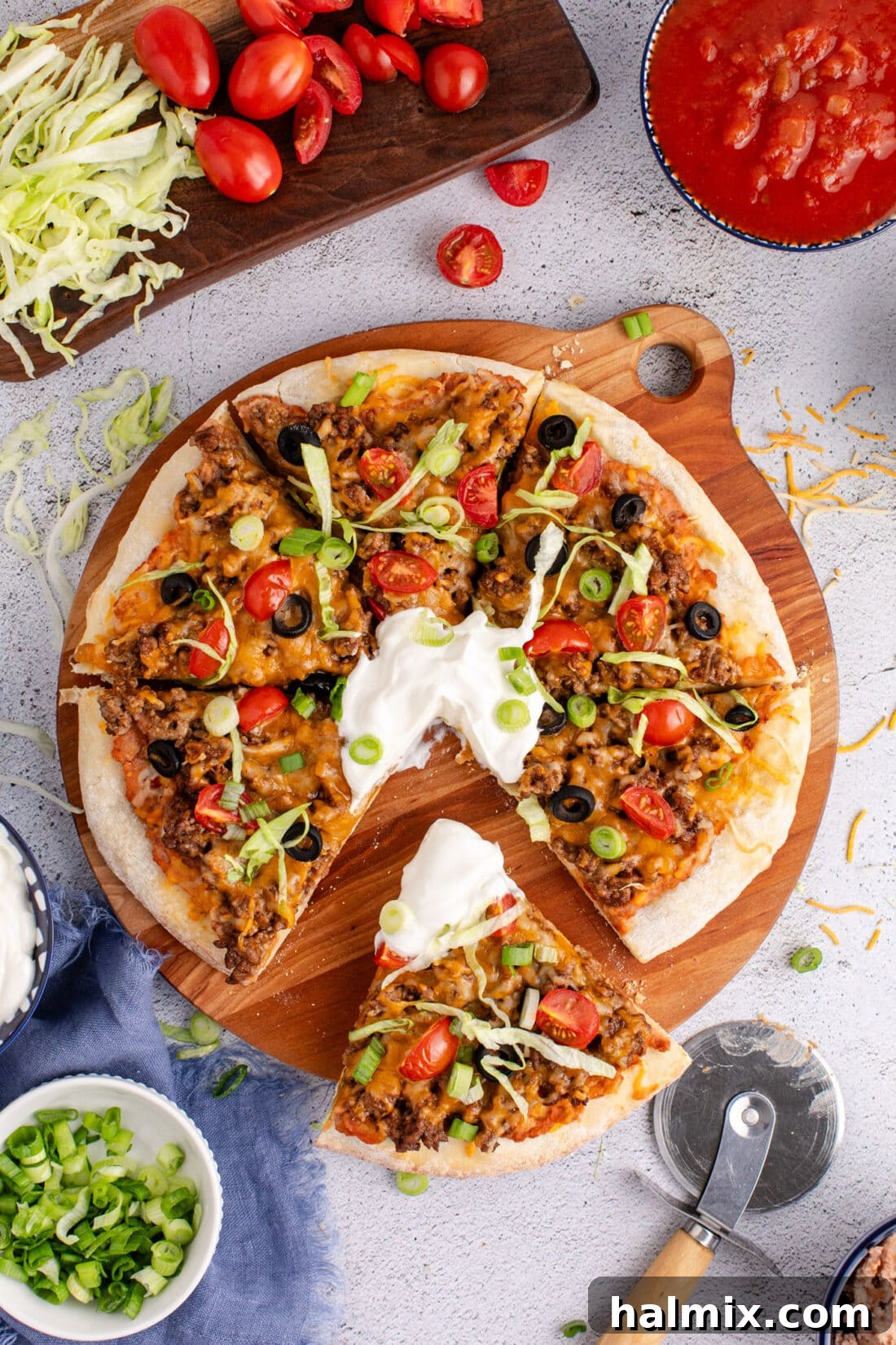 Overhead photo of a Taco Pizza cut into slices, showcasing its vibrant toppings