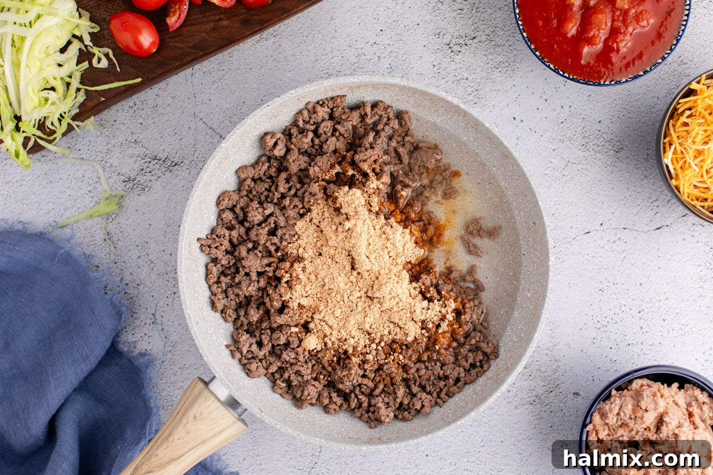 Taco seasoning and water added to ground beef in a skillet