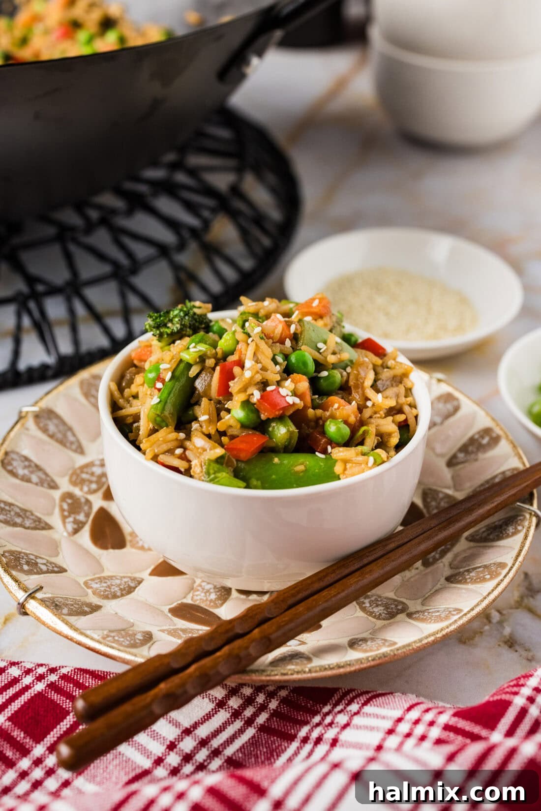 Bowl of Ultimate Vegetable Fried Rice with chopsticks on the side