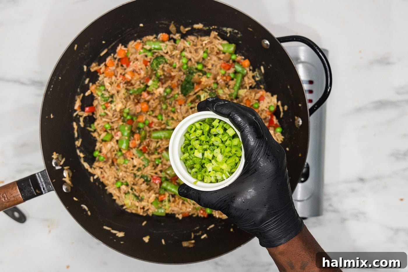 sliced green onions in a bowl over vegetable fried rice