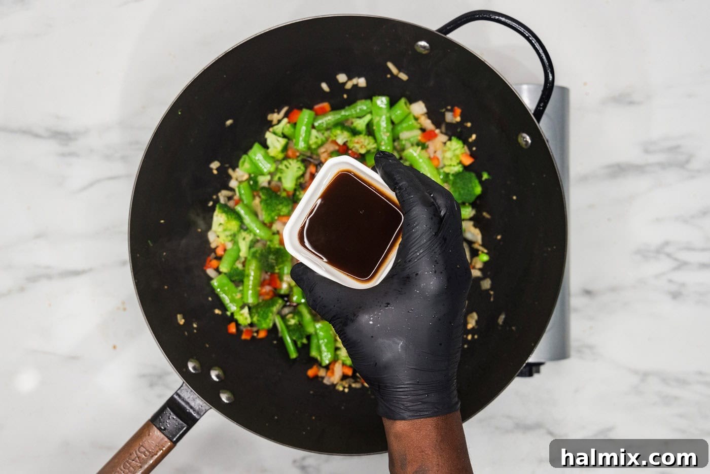 Oyster sauce over a skillet over vegetables
