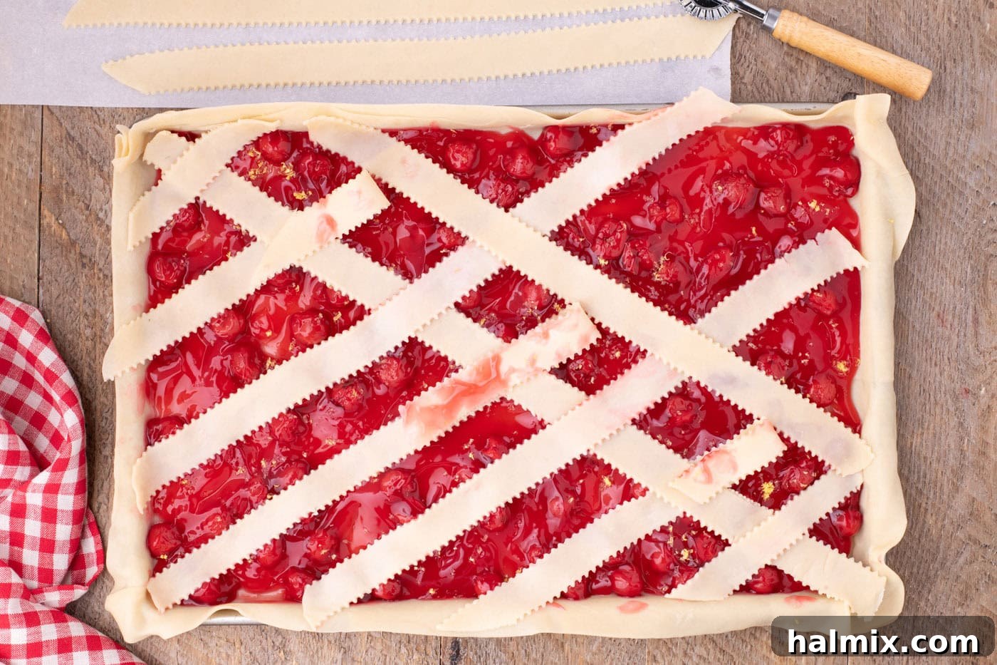 arranging pie crust weave on top of cherry pie filling
