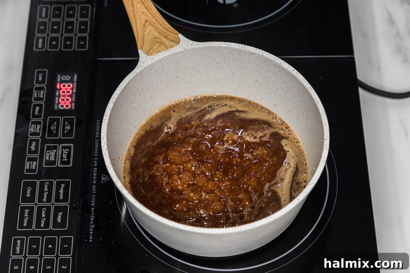 Sticky Honey Garlic Tofu 11 Thickened honey garlic sauce simmering in a saucepan, showcasing its glossy, sticky texture.