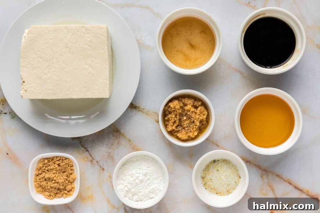 Sticky Honey Garlic Tofu 4 Ingredients for Honey Garlic Tofu laid out on a table, including tofu, honey, soy sauce, and garlic.