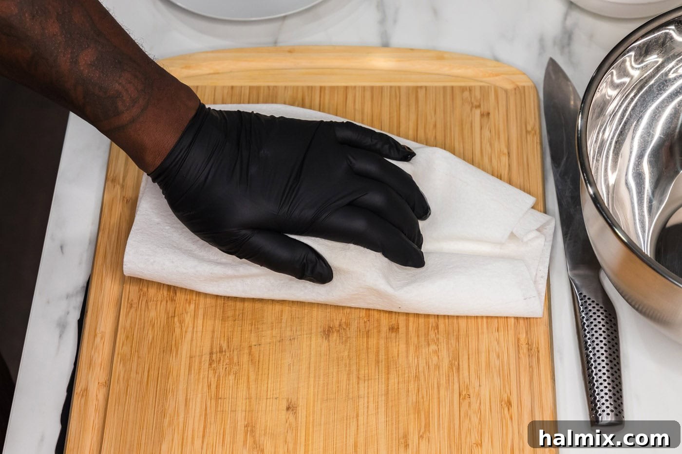 Sticky Honey Garlic Tofu 5 Hand squeezing out excess moisture from tofu with a paper towel, a critical step for crispy results.