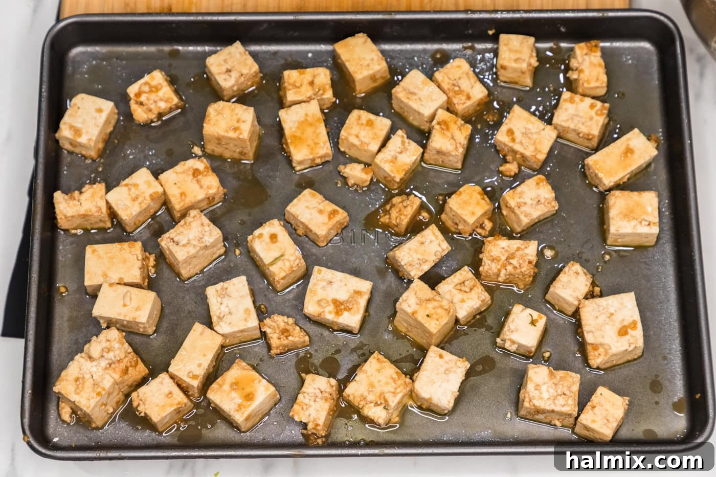 Sticky Honey Garlic Tofu 9 Sheet pan filled with honey garlic tofu cubes, baking to a golden crisp in the oven.