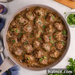 Overhead photo of a skillet of Salisbury Steak Meatballs, perfectly browned and coated in a rich mushroom gravy.