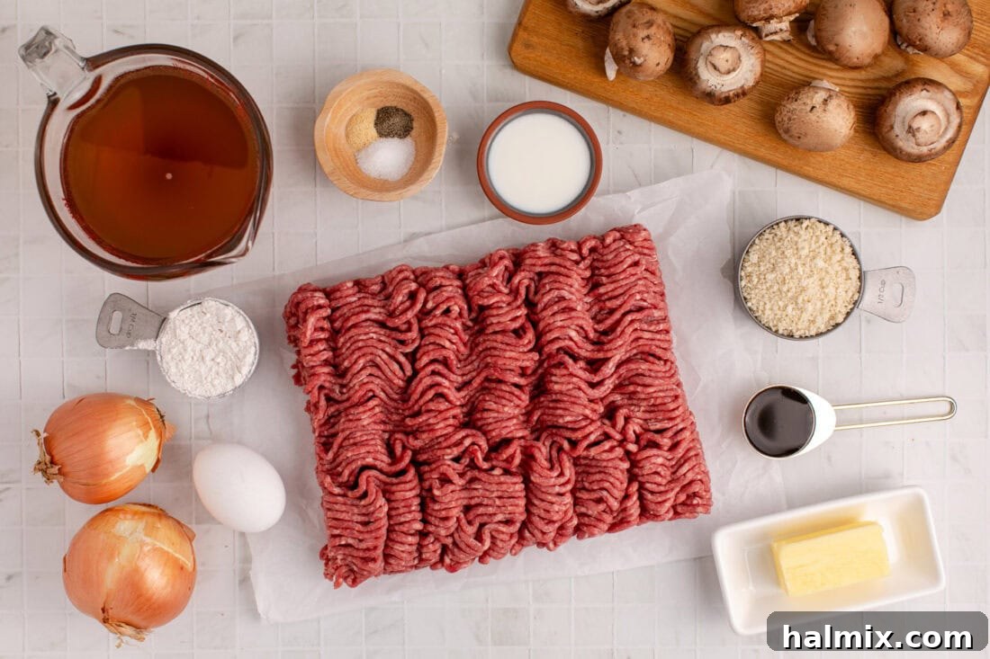 A flat lay of fresh ingredients for Salisbury Steak Meatballs, including ground beef, mushrooms, onions, and various seasonings.