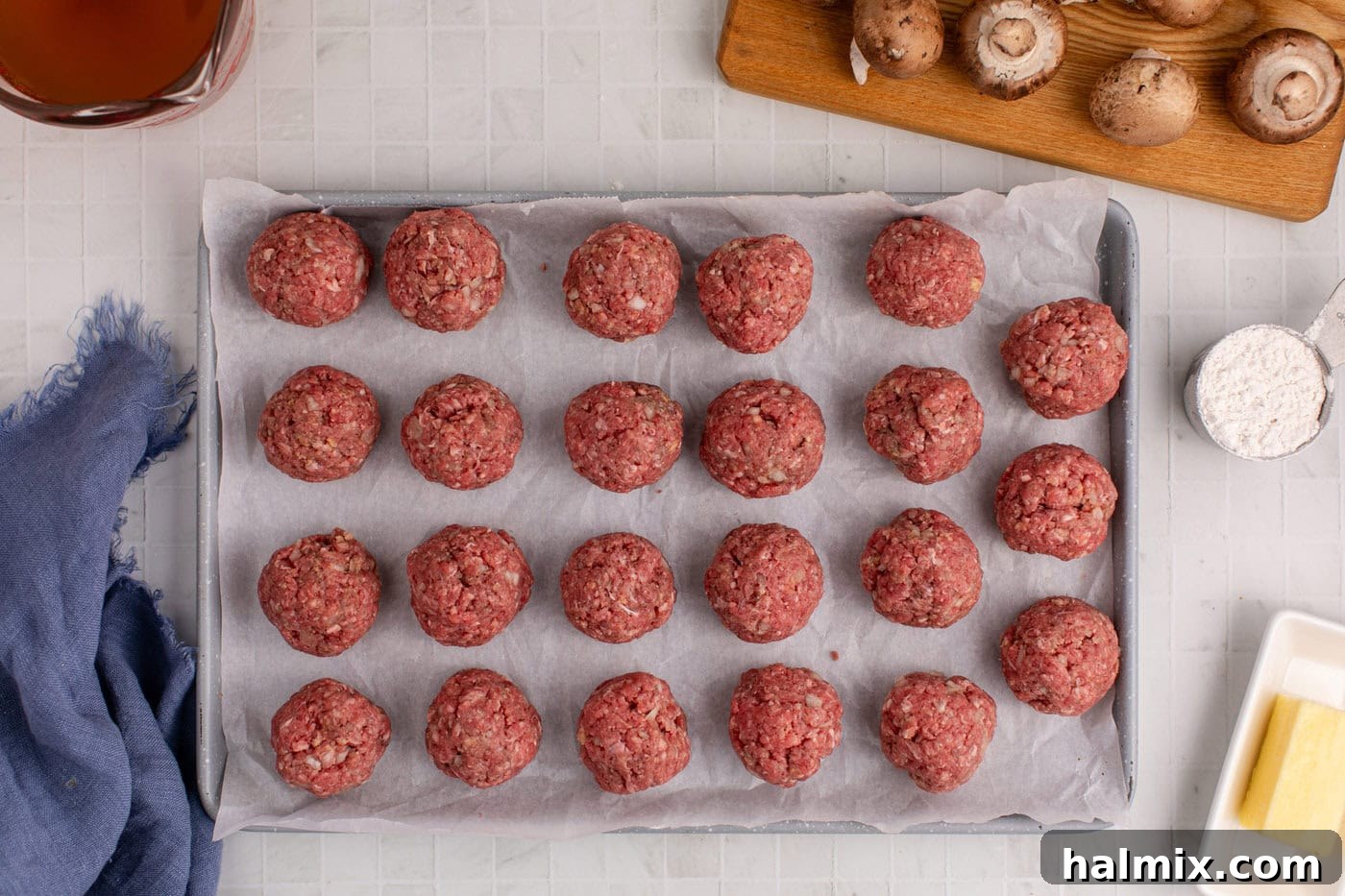 Meatballs neatly arranged on parchment paper, ready for cooking