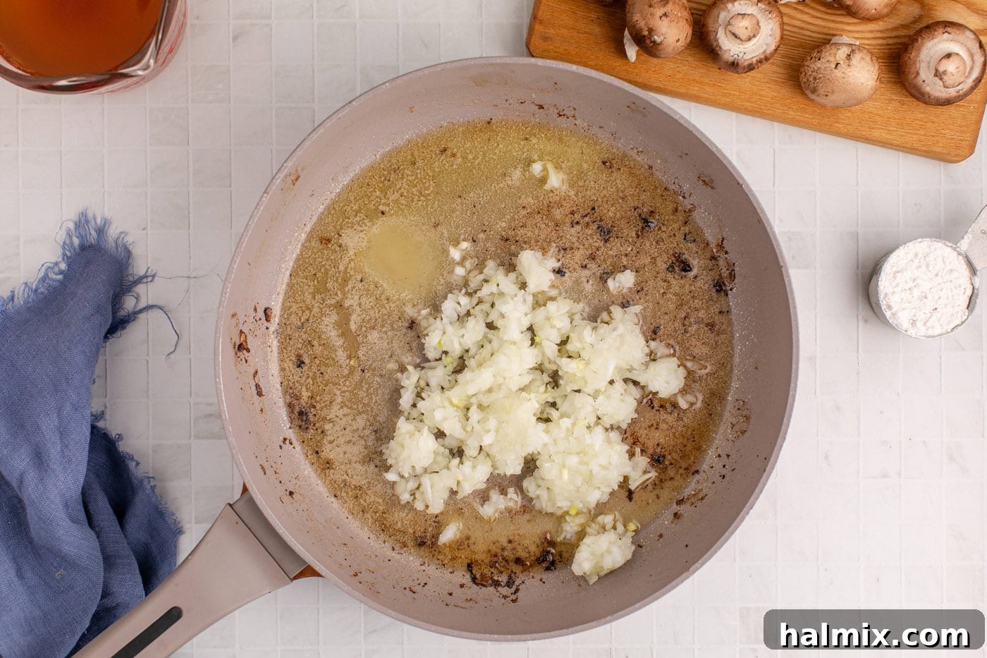 Chopped onion being cooked in melted butter in a skillet