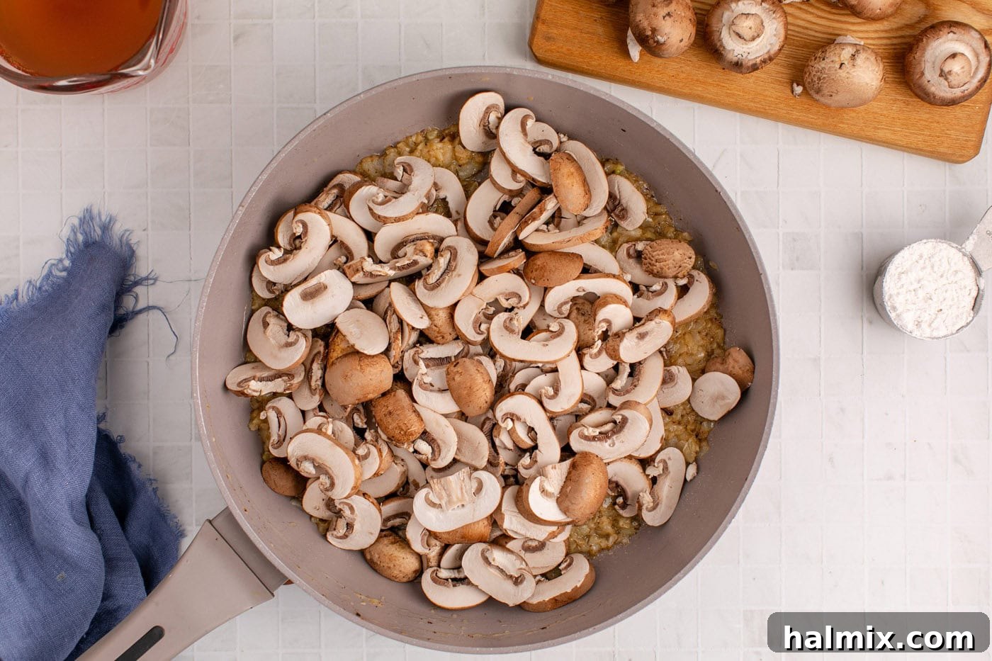 Sliced mushrooms added to the skillet with sauteed onion, creating the base for the mushroom gravy