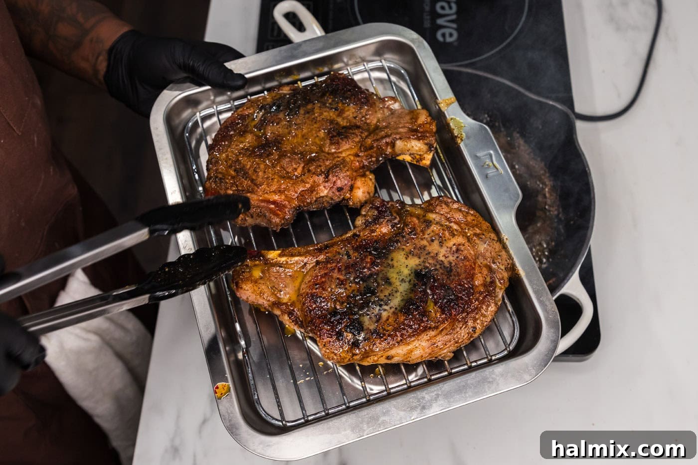 transferring ribeye steaks to a baking sheet