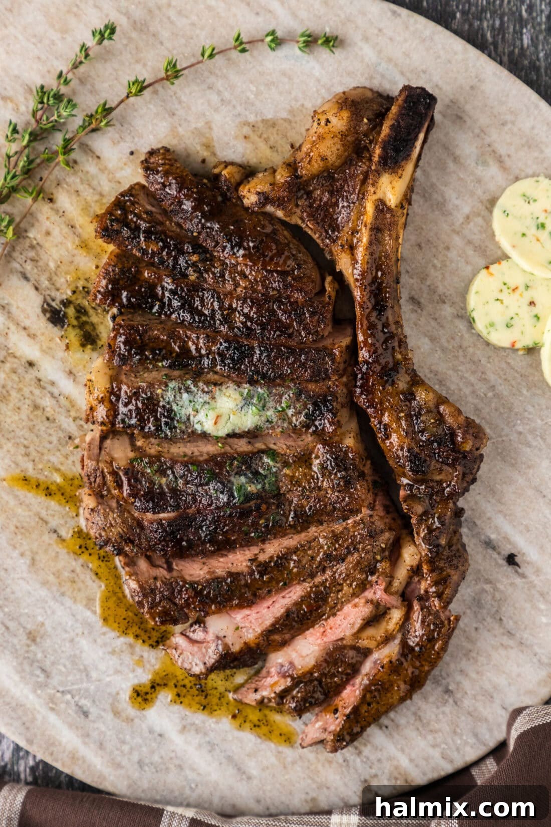Bone in Ribeye cut into slices on a marble serving board