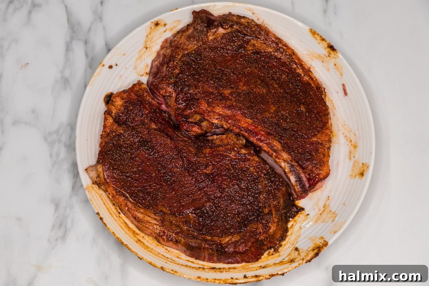 seasoned ribeye steaks on a plate