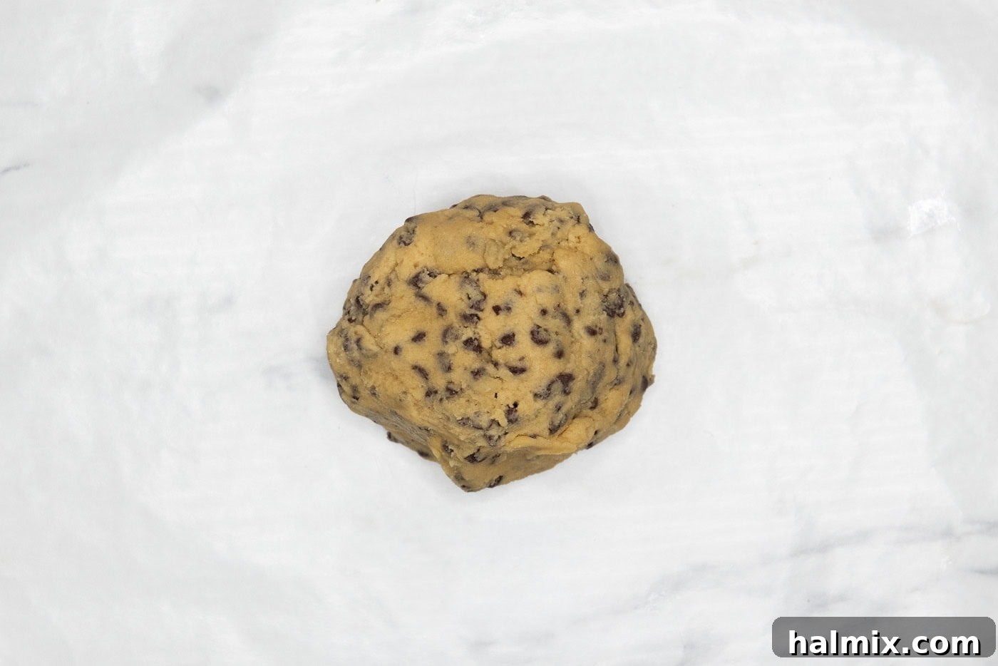 chocolate chip cookie dough ball in parchment paper