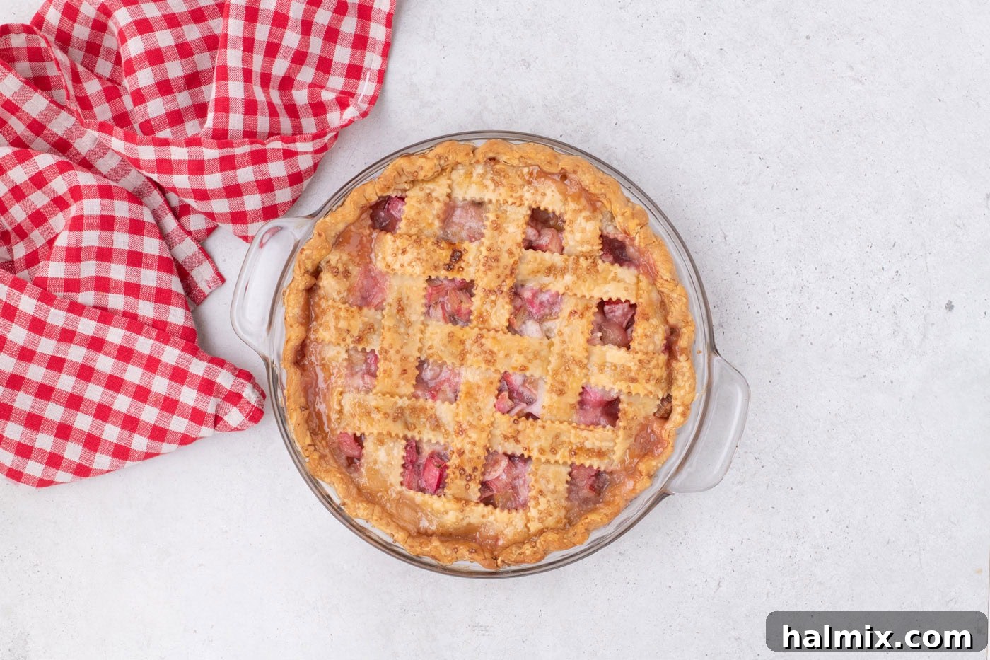 Tangy Rhubarb Delight 20 An overhead view of a freshly baked rhubarb pie in a pie plate, cooling on a wire rack.