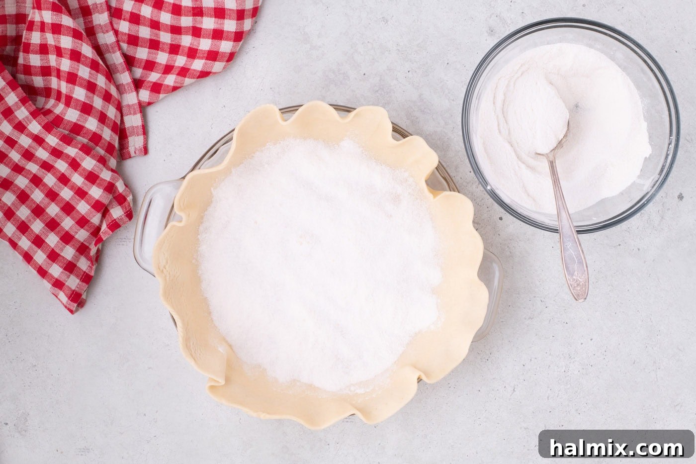 Tangy Rhubarb Delight 7 A pie crust with a layer of white sugar mixture sprinkled at the bottom.