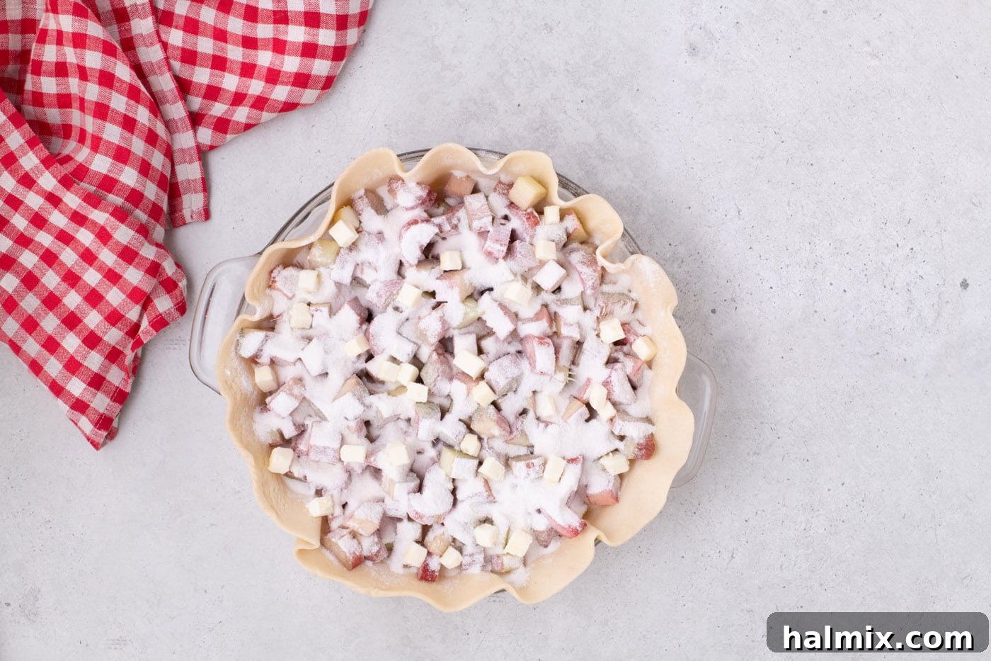 Tangy Rhubarb Delight 9 The second layer of chopped rhubarb sprinkled with sugar in a pie crust.