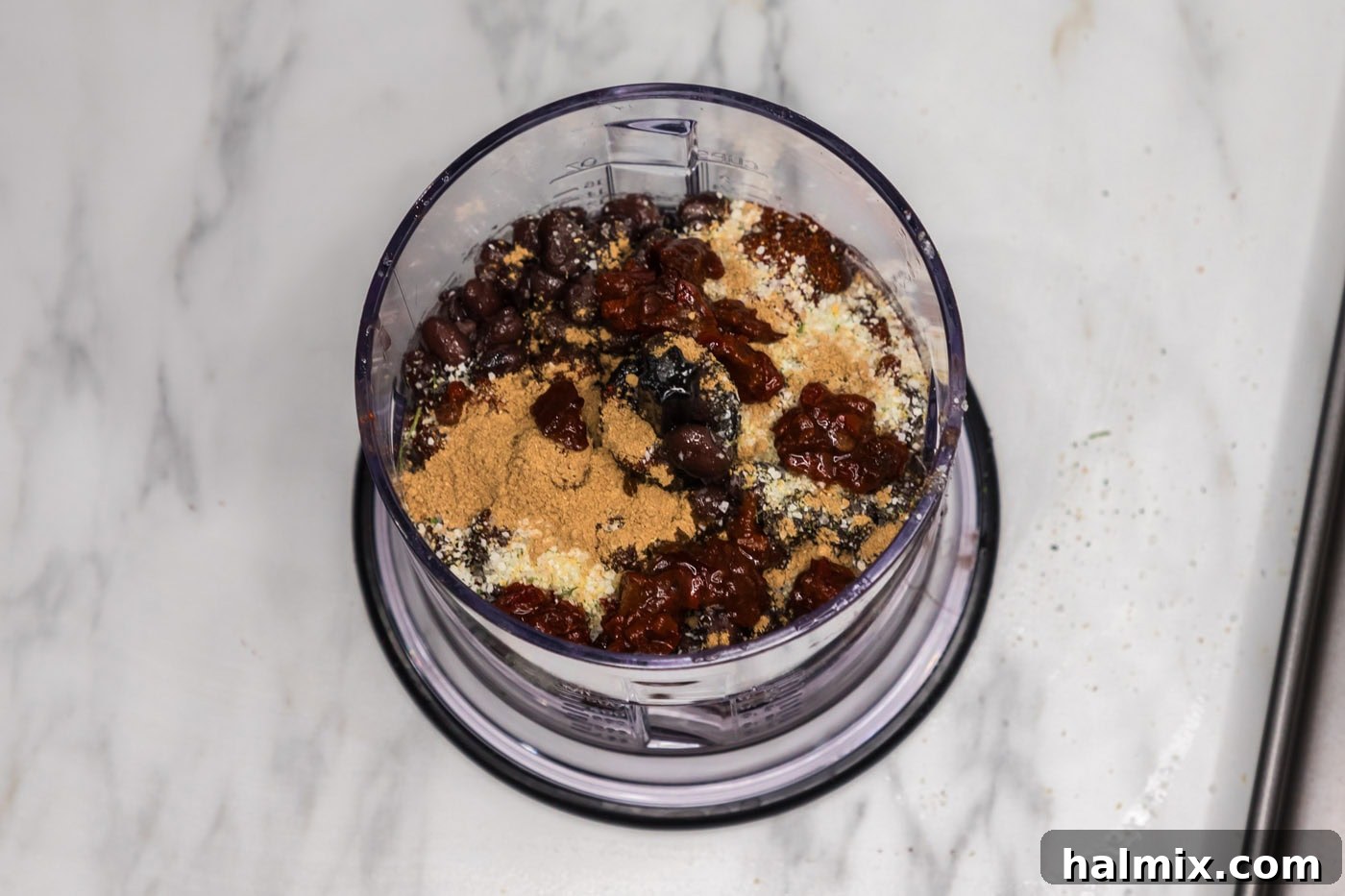 black beans in a food processor with seasonings, chipotle peppers, and soy sauce
