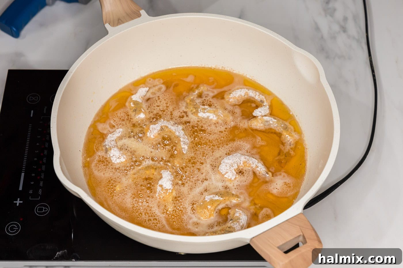 Thunder Shrimp 12 Frying shrimp in hot oil in a skillet, turning golden.