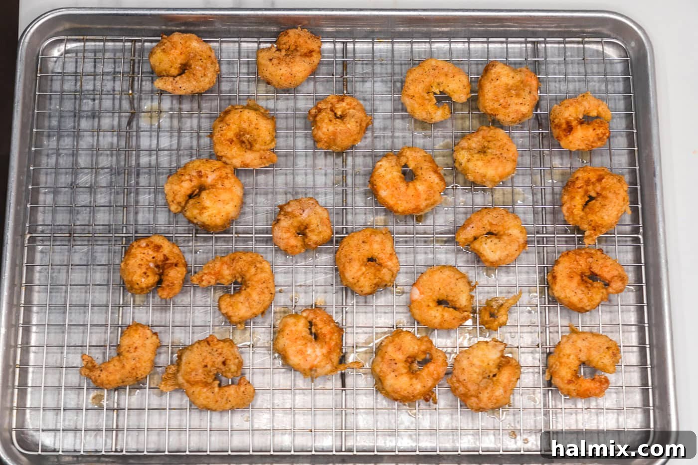 Thunder Shrimp 14 Fried shrimp resting on a wire rack to drain excess oil.