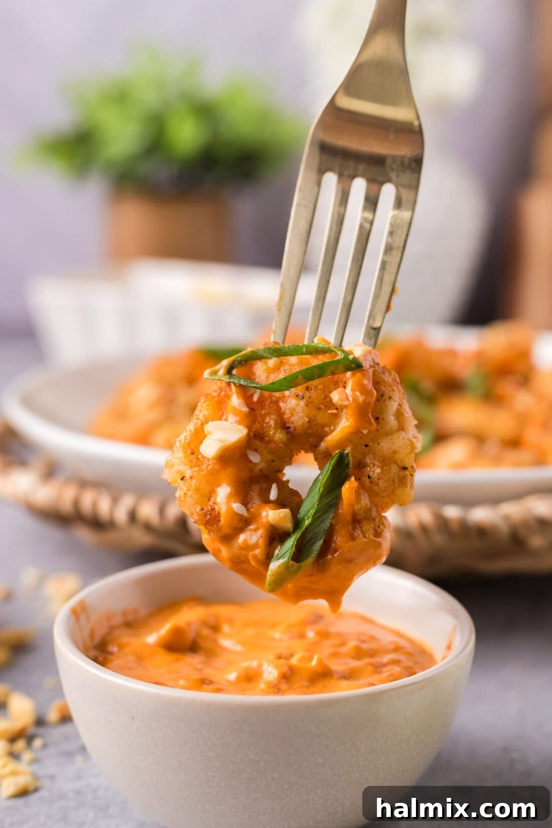 Thunder Shrimp 15 Boom Boom Shrimp on a fork held over a bowl of sauce, ready for a bite.