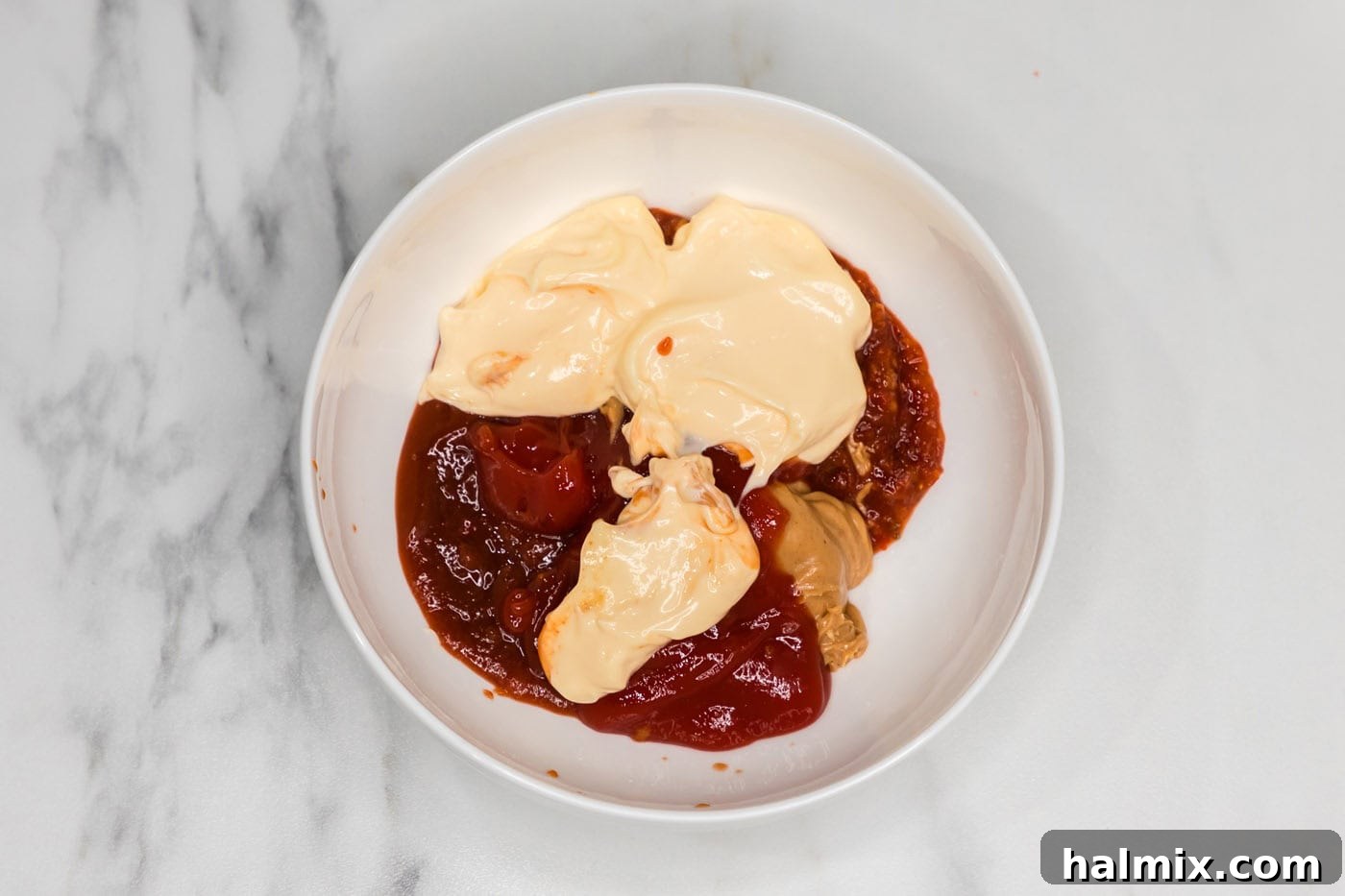 Thunder Shrimp 5 Peanut butter, Asian sweet chili sauce, sriracha, ketchup, and mayonnaise being combined in a bowl.
