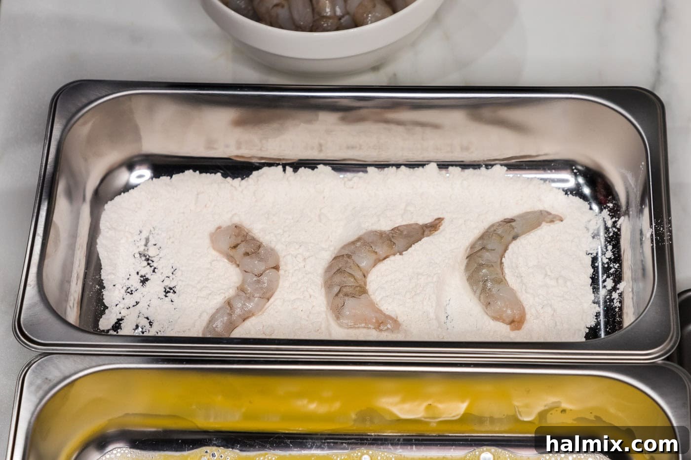 Thunder Shrimp 7 Shrimp being dipped into the first tray of flour.