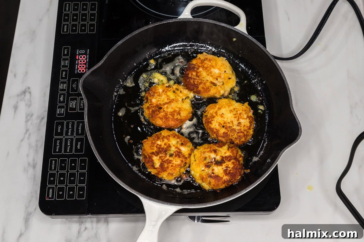 Golden Cod Fritters 5 Pan fried cod fish cakes in a skillet