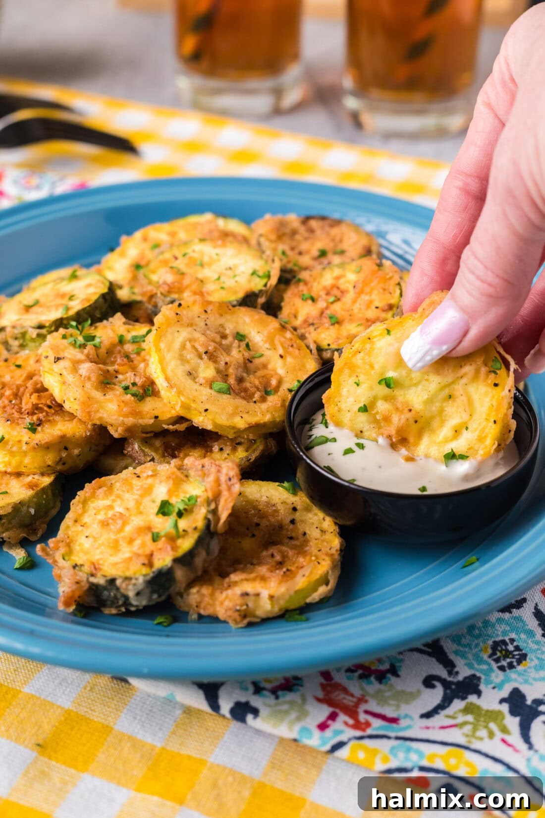 Golden Fried Squash 2 Crispy Fried Squash being dipped in ranch dressing, showcasing its golden perfection.