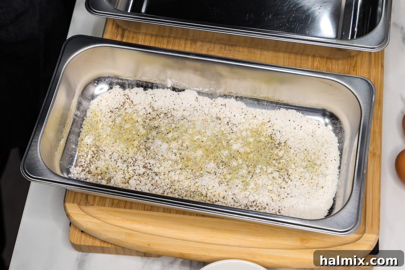 Golden Fried Squash 5 Dredging tray containing a mixture of flour, black pepper, and garlic salt, ready for breading.