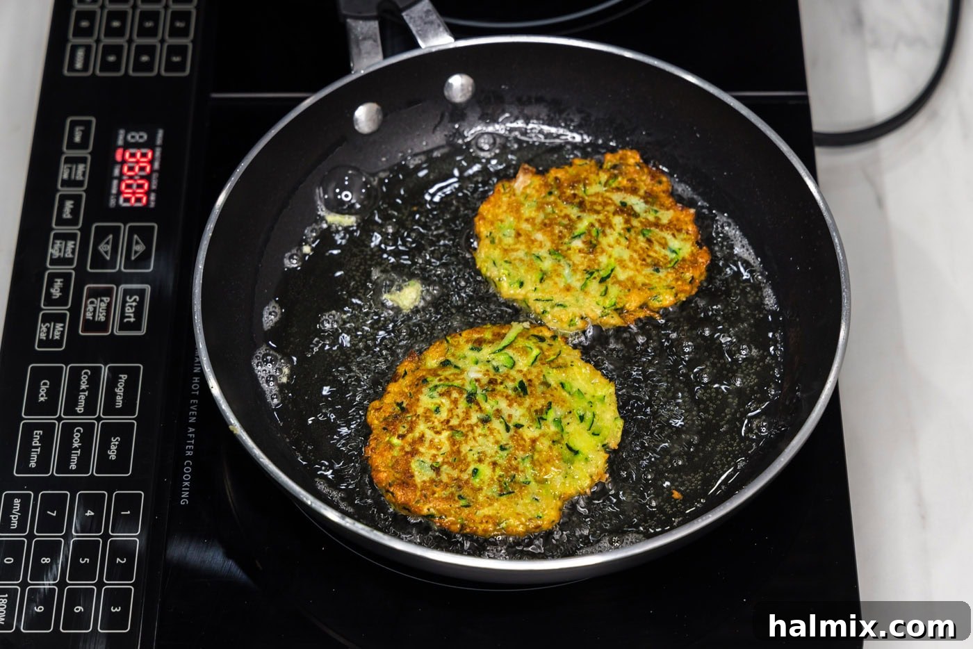 Golden Zucchini Delights 11 Zucchini fritters frying in hot oil in a skillet, turning golden