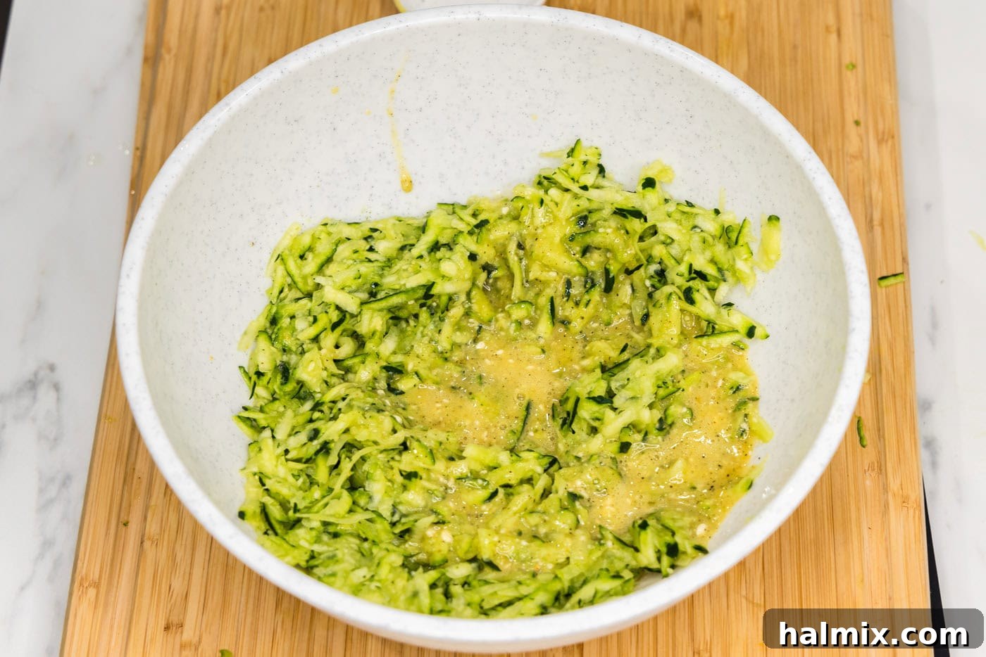 Golden Zucchini Delights 7 Beaten egg mixture being added to shredded zucchini in a bowl