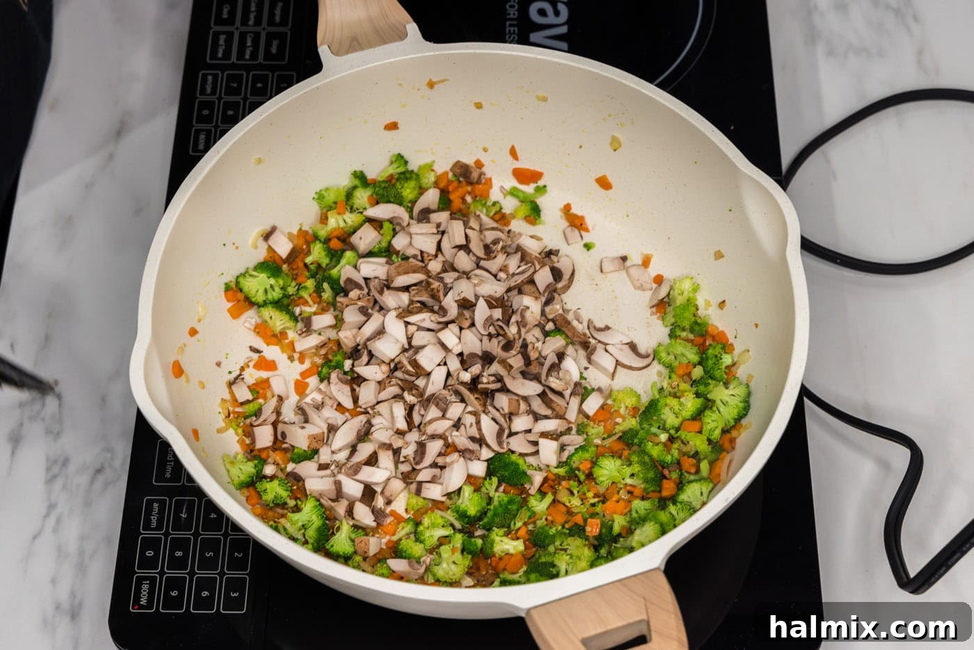 broccoli and mushrooms added to skillet with carrots and garlic