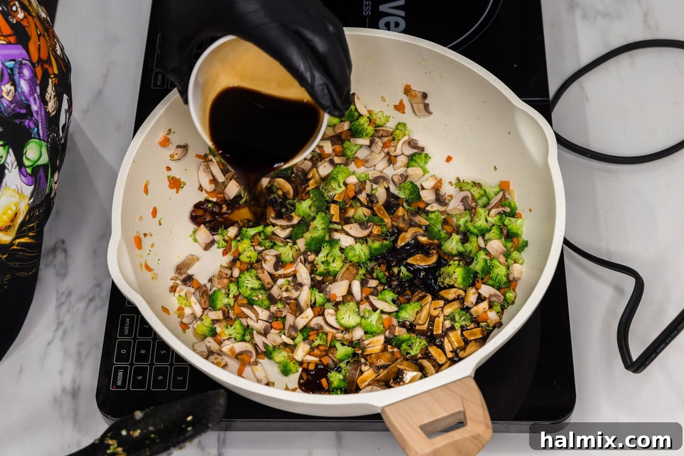 pouring soy sauce into skillet with chopped vegetables