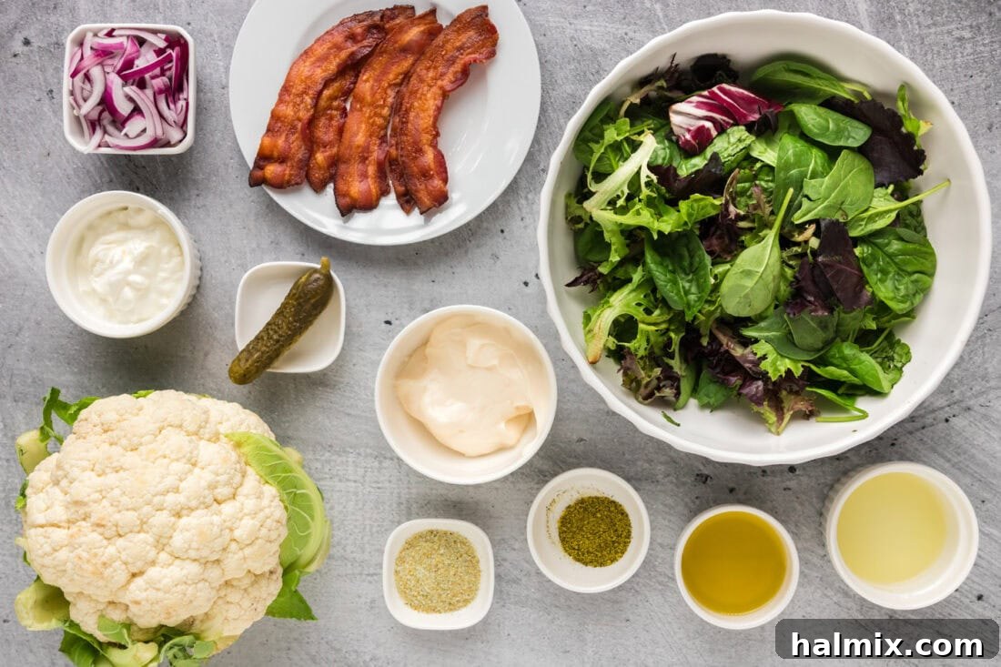 Ingredients for Cauliflower Salad laid out on a table, including cauliflower, bacon, lettuce, and dressing components.