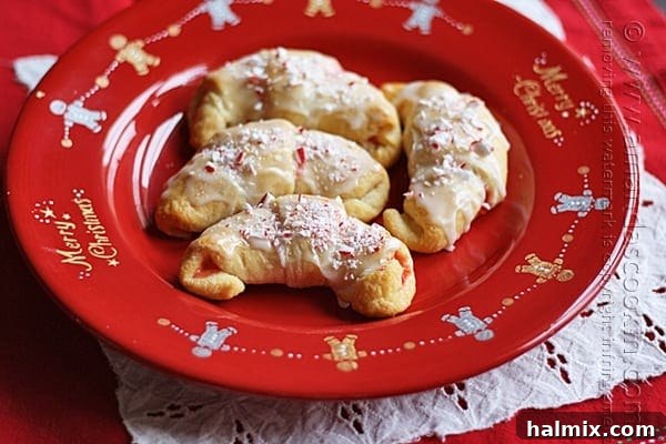 Snowy Peppermint Crescents 2 A close up overhead of a white chocolate candy cane crescents on a red plate.