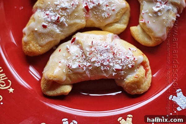 Snowy Peppermint Crescents 4 A close up photo of a white chocolate candy cane crescent on a red plate.