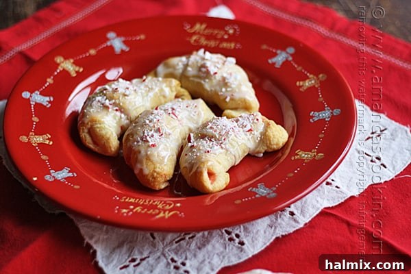 Snowy Peppermint Crescents 5 A close up overhead of white chocolate candy cane crescents on a red plate.