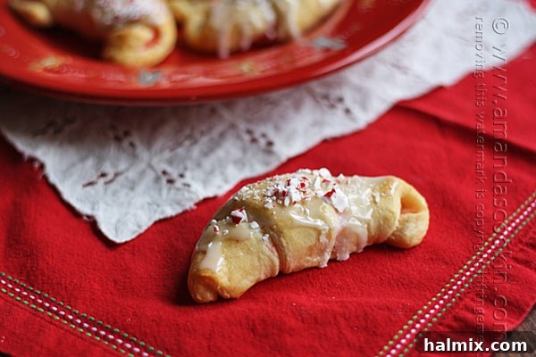 Snowy Peppermint Crescents 6 A close up photo of a white chocolate candy cane crescent on a red plate.