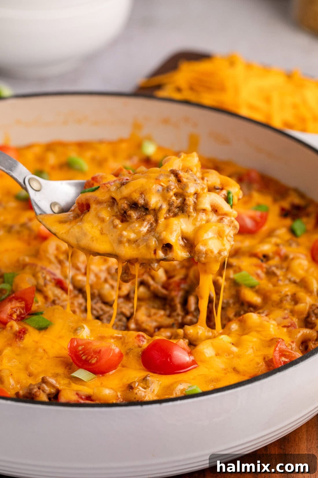 Loaded Taco Macaroni and Cheese 2 Spoon lifting Taco Macaroni and Cheese out of a skillet