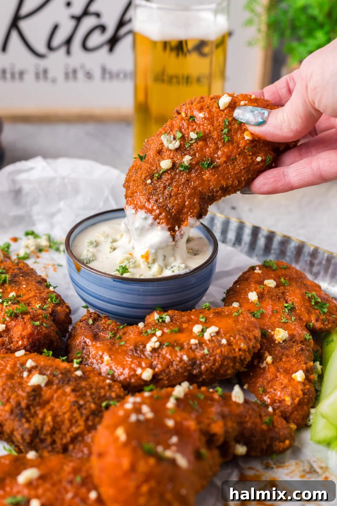Buffalo Chicken Tender being dipped into blue cheese dressing