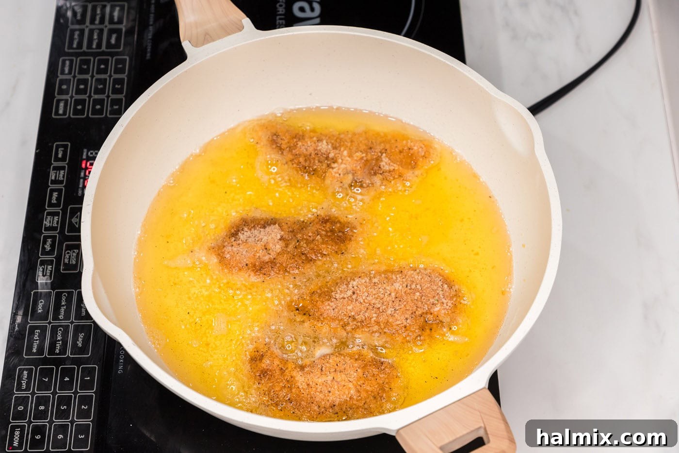 frying buffalo chicken tenders in a skillet of oil
